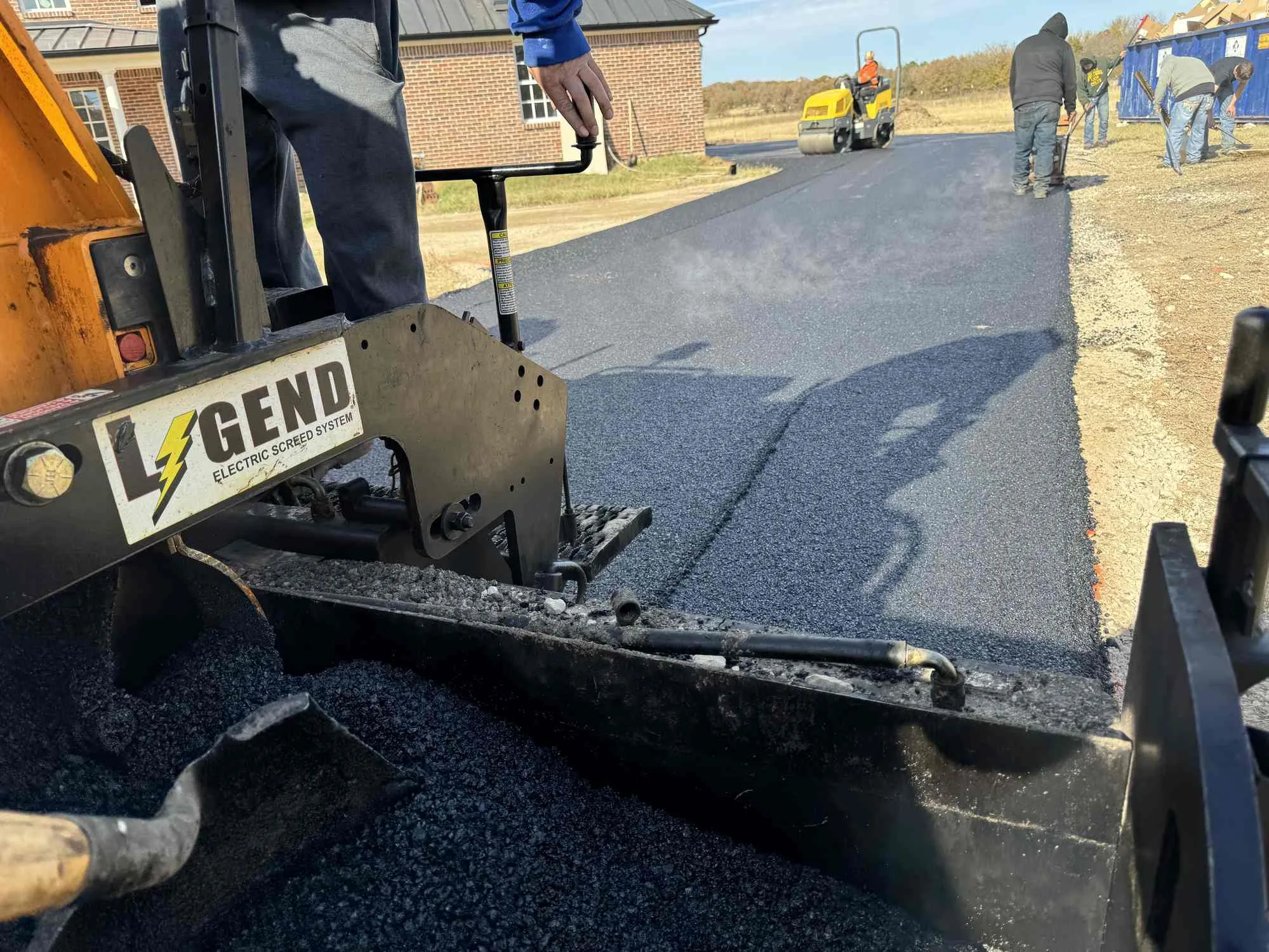 Crew paving a fresh asphalt surface